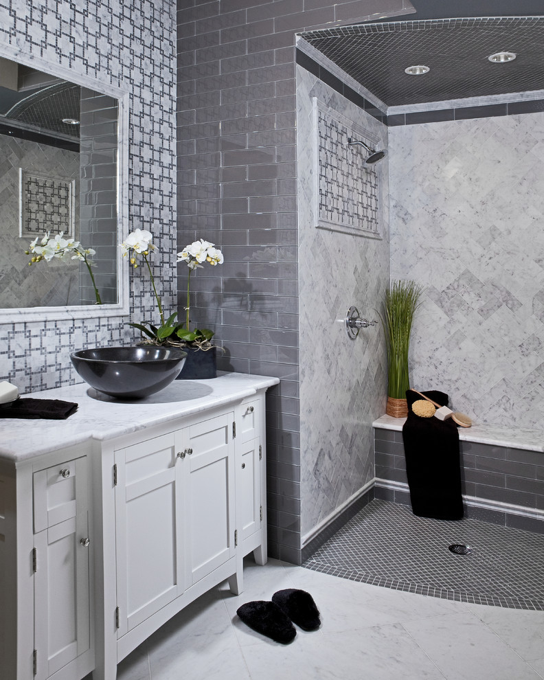 Cette photo montre une salle de bain grise et noire moderne avec un plan de toilette en marbre, une vasque et du carrelage en marbre.