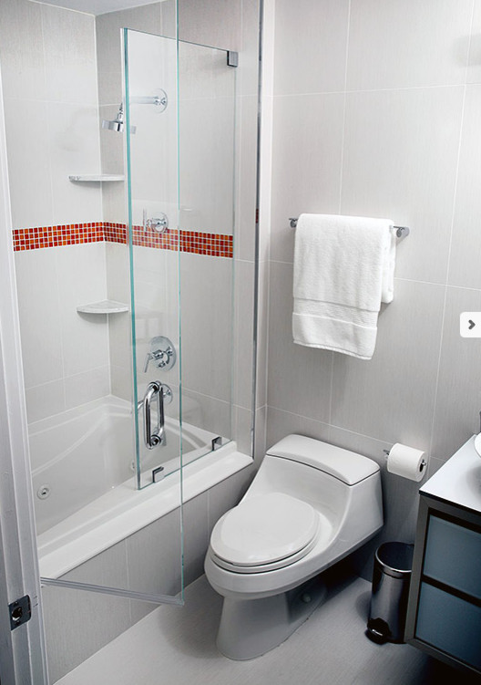 Immagine di una piccola stanza da bagno moderna con ante di vetro, ante bianche, piastrelle di vetro, pareti grigie, lavabo a bacinella, top in vetro, vasca/doccia, WC monopezzo e piastrelle bianche