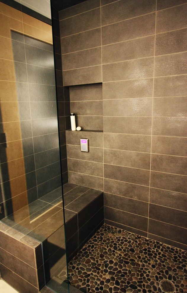 Cette image montre une grande salle de bain principale minimaliste avec une douche d'angle, WC à poser, un carrelage marron, une plaque de galets et une vasque.