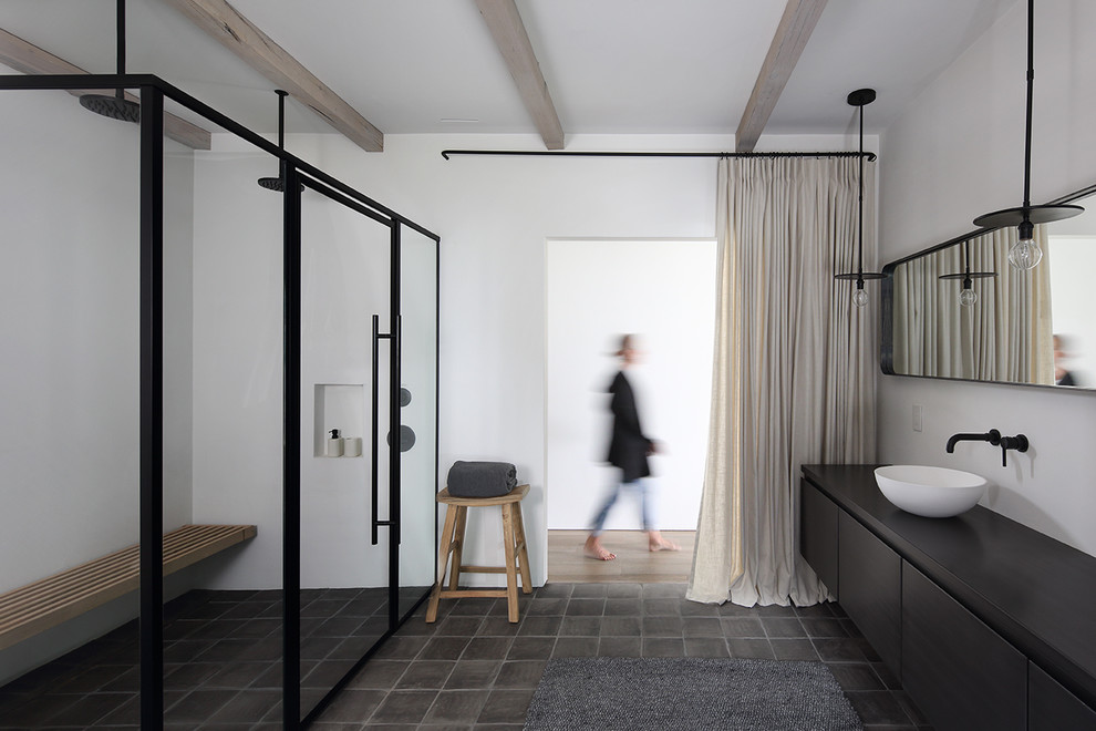 Inspiration för ett funkis svart svart en-suite badrum, med släta luckor, en kantlös dusch, vita väggar, klinkergolv i terrakotta, ett fristående handfat, dusch med gångjärnsdörr, svarta skåp och grått golv