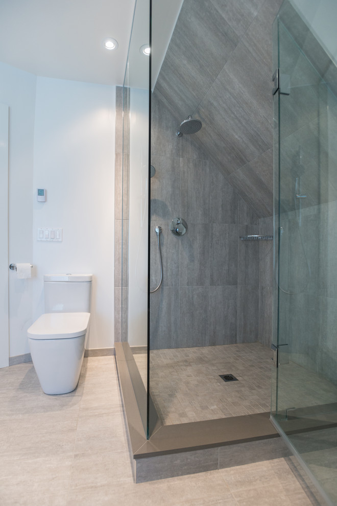 Photo of a large modern ensuite bathroom in Toronto with a corner shower, a one-piece toilet, grey tiles, porcelain tiles, white walls and limestone flooring.