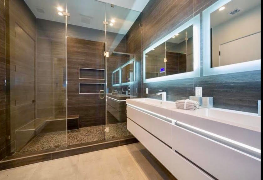 Example of a large minimalist master brown tile brown floor bathroom design in Los Angeles with white cabinets, brown walls, a hinged shower door and white countertops