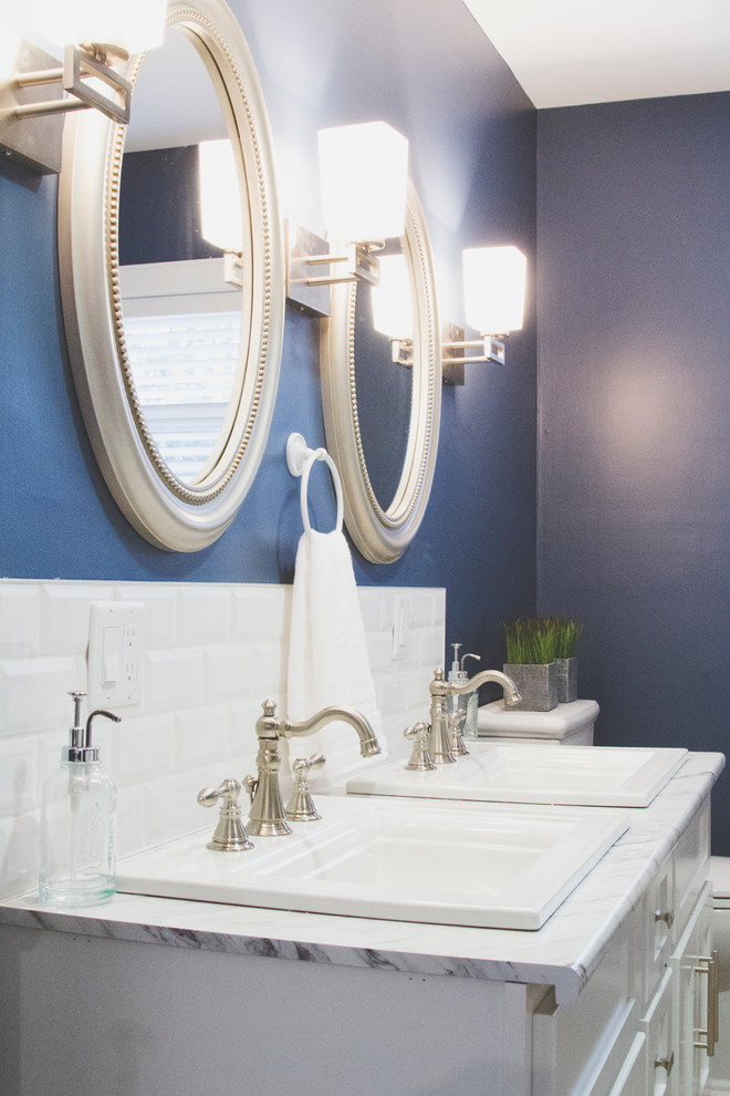 На фото: большая главная ванная комната в стиле неоклассика (современная классика) с фасадами в стиле шейкер, белыми фасадами, ванной в нише, душем в нише, унитазом-моноблоком, бежевой плиткой, керамической плиткой, синими стенами, полом из линолеума, накладной раковиной и столешницей из ламината