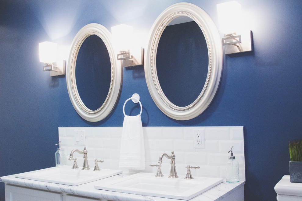 Modelo de cuarto de baño principal clásico renovado grande con armarios estilo shaker, puertas de armario blancas, bañera empotrada, ducha empotrada, sanitario de una pieza, baldosas y/o azulejos beige, baldosas y/o azulejos de cerámica, paredes azules, suelo de linóleo, lavabo encastrado y encimera de laminado