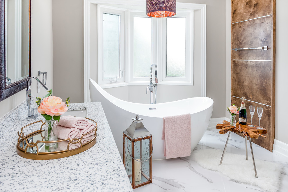 Immagine di una grande stanza da bagno padronale minimalista con ante bianche, vasca freestanding, pareti beige, pavimento in gres porcellanato, lavabo sottopiano, top piastrellato e pavimento bianco