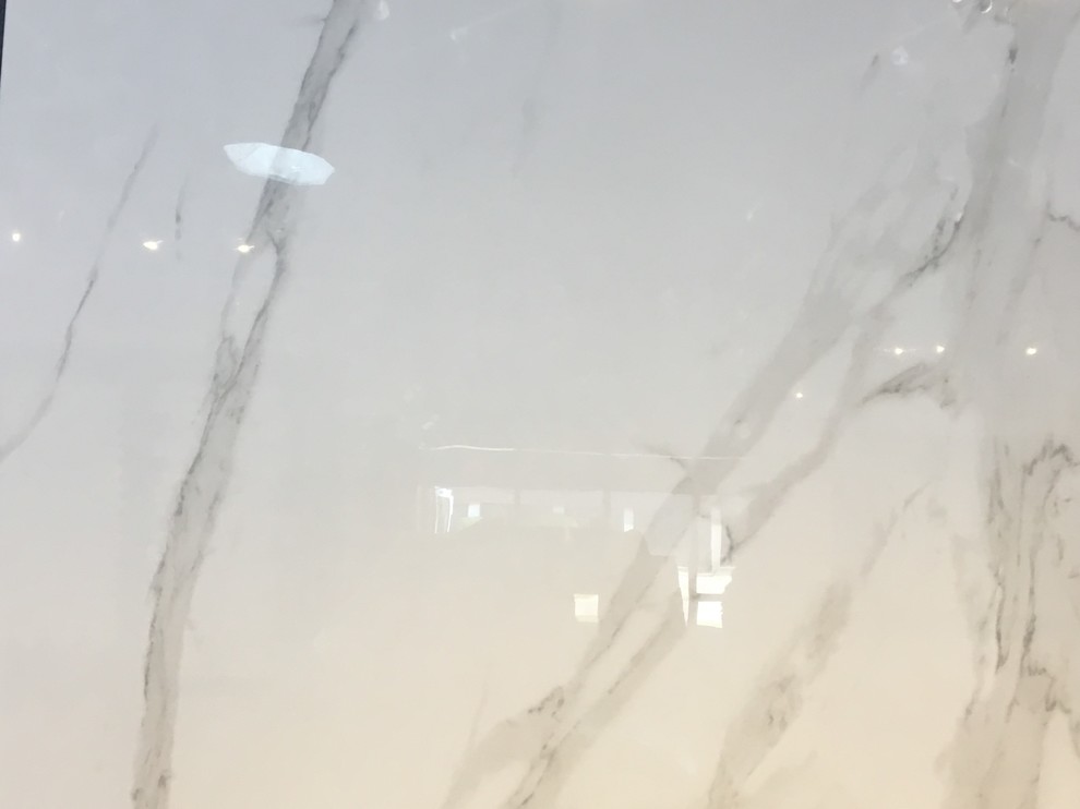 Imagen de cuarto de baño principal moderno grande con puertas de armario blancas, bañera exenta, paredes beige, suelo de baldosas de porcelana, lavabo bajoencimera, encimera de azulejos y suelo blanco