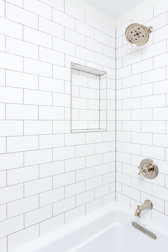 Idée de décoration pour une salle de bain principale minimaliste de taille moyenne avec un placard à porte plane, des portes de placard noires, une baignoire posée, un combiné douche/baignoire, WC à poser, un carrelage blanc, un carrelage métro, un mur blanc, un sol en vinyl, un lavabo encastré et un plan de toilette en granite.