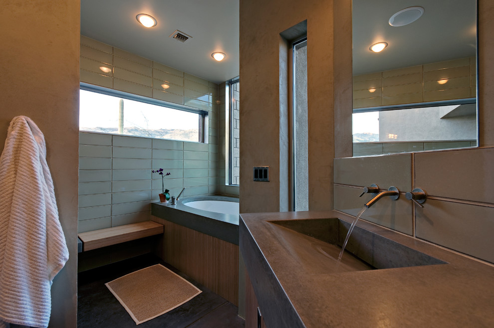 Imagen de cuarto de baño contemporáneo con lavabo integrado, armarios con paneles lisos, puertas de armario de madera oscura, encimera de cemento, bañera encastrada, ducha empotrada, sanitario de una pieza, baldosas y/o azulejos verdes y baldosas y/o azulejos de cerámica