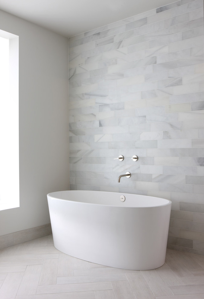 Diseño de cuarto de baño minimalista con bañera exenta y ventanas
