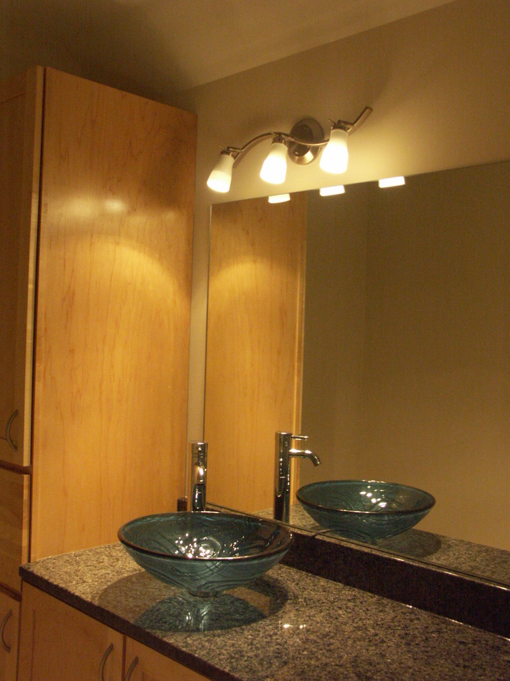 Inspiration pour une salle de bain principale design en bois clair avec un placard sans porte, une baignoire en alcôve, un carrelage beige, un carrelage de pierre, une vasque et un plan de toilette en granite.
