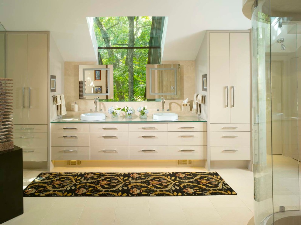 Идея дизайна: большая главная ванная комната в современном стиле с плоскими фасадами, белыми фасадами, угловым душем, бежевой плиткой, каменной плиткой, белыми стенами, полом из керамогранита, настольной раковиной и стеклянной столешницей