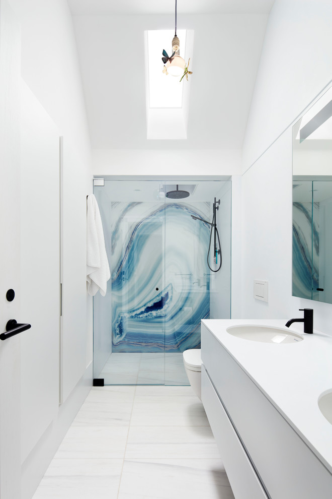 Immagine di una stanza da bagno con doccia moderna con ante lisce, ante bianche, doccia alcova, pareti bianche, lavabo sottopiano, pavimento bianco e porta doccia a battente