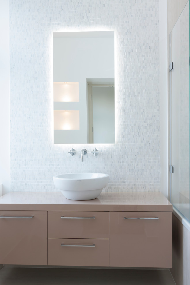 Photo of a modern bathroom in Other with a vessel sink and white tiles.