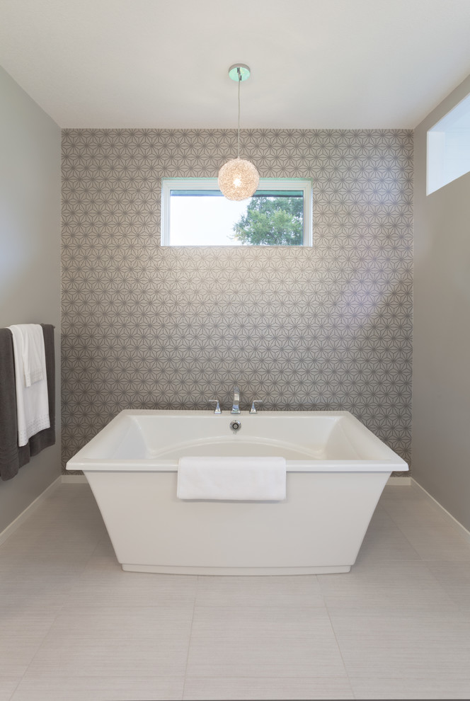 На фото: ванная комната в стиле неоклассика (современная классика) с отдельно стоящей ванной и серыми стенами с