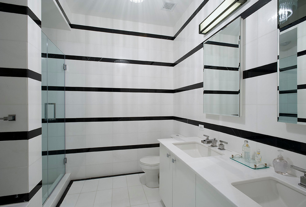 ニューヨークにあるモダンスタイルのおしゃれな浴室 (アンダーカウンター洗面器、フラットパネル扉のキャビネット、白いキャビネット、アルコーブ型シャワー、モノトーンのタイル) の写真