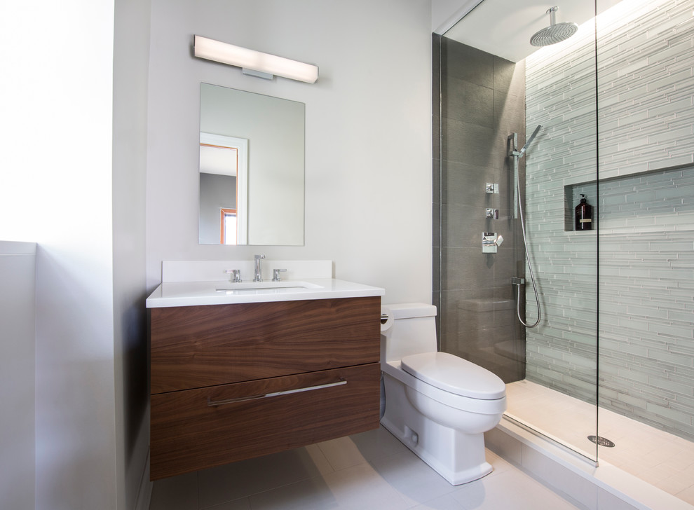 Alcove shower - mid-sized contemporary 3/4 gray tile and matchstick tile porcelain tile alcove shower idea in Chicago with flat-panel cabinets, medium tone wood cabinets, a one-piece toilet, white walls, an undermount sink and quartz countertops