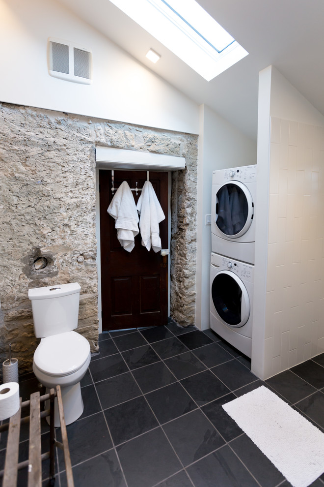 Bild på ett mellanstort rustikt en-suite badrum, med luckor med upphöjd panel, skåp i mörkt trä, en kantlös dusch, en toalettstol med separat cisternkåpa, svart och vit kakel, keramikplattor, vita väggar, ett fristående handfat och träbänkskiva