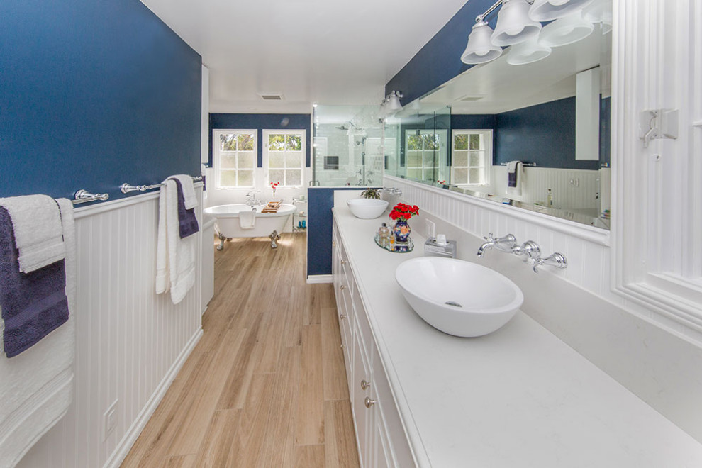 Idée de décoration pour une grande salle de bain principale minimaliste avec des portes de placard blanches, une baignoire sur pieds, un espace douche bain, un carrelage bleu, un mur bleu, sol en stratifié, une vasque, un plan de toilette en granite, un sol marron, une cabine de douche à porte battante, un plan de toilette blanc et un placard à porte affleurante.