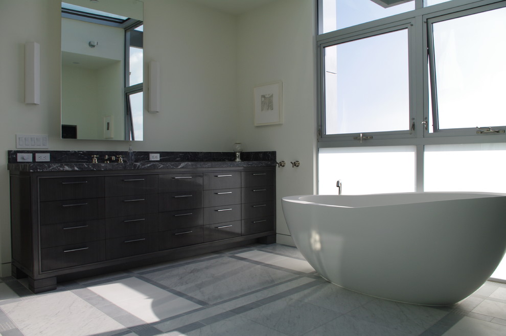 Exempel på ett modernt badrum, med ett fristående badkar och stenkakel