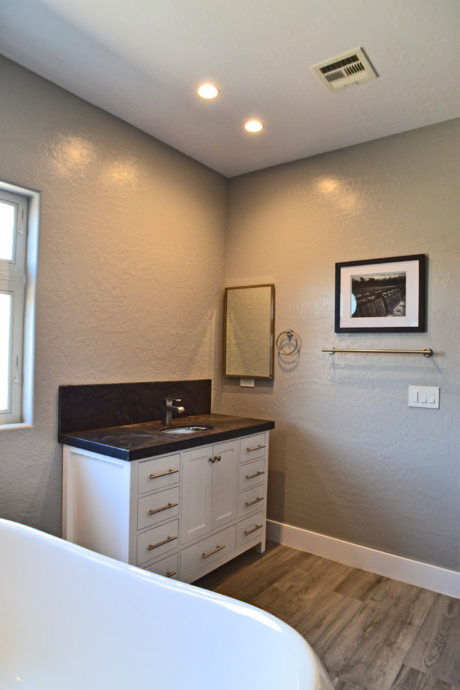 Example of a transitional black tile and porcelain tile porcelain tile bathroom design in Las Vegas with shaker cabinets, white cabinets, a two-piece toilet, gray walls, an undermount sink and granite countertops