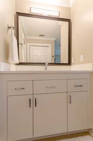 Inredning av ett modernt mellanstort badrum med dusch, med släta luckor, vita skåp, beige väggar, ljust trägolv och ett undermonterad handfat