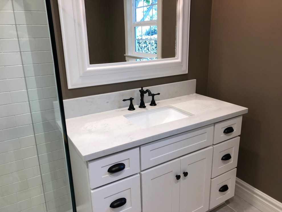 Medium sized modern ensuite bathroom in Los Angeles with shaker cabinets, white cabinets, a corner shower, a two-piece toilet, brown walls, a submerged sink, quartz worktops, grey floors, a hinged door and white worktops.