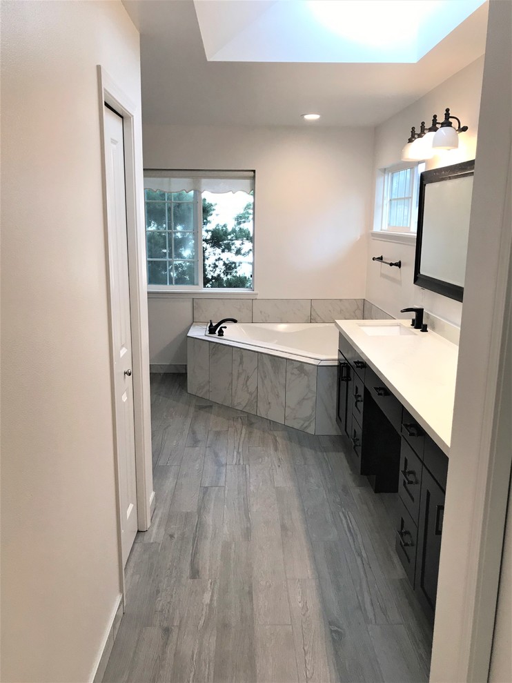 Example of a large minimalist master ceramic tile and gray tile bathroom design in Seattle with flat-panel cabinets, black cabinets, white walls, an integrated sink, quartzite countertops and white countertops
