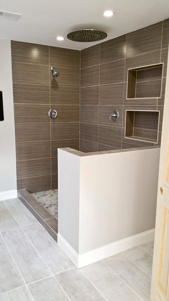 Foto på ett stort funkis en-suite badrum, med ett undermonterad handfat, bänkskiva i kvartsit, ett fristående badkar, en öppen dusch, grå kakel, kakel i småsten, grå väggar och klinkergolv i porslin