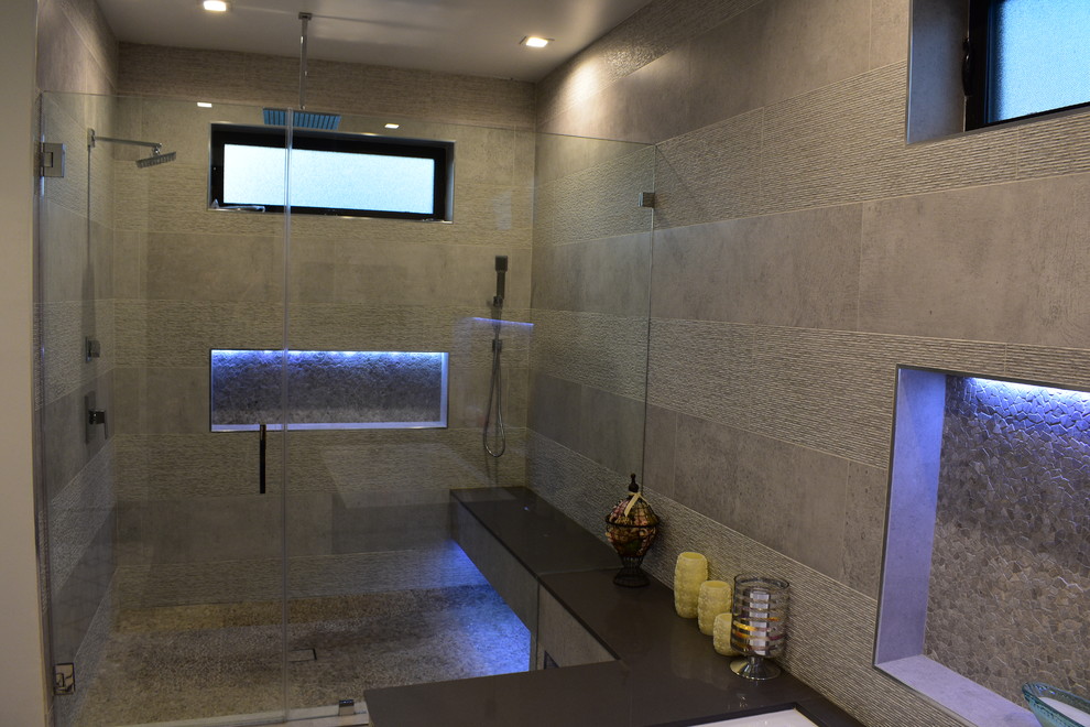 Пример оригинального дизайна: огромная главная ванная комната в стиле модернизм с фасадами с выступающей филенкой, светлыми деревянными фасадами, накладной ванной, двойным душем, унитазом-моноблоком, серой плиткой, каменной плиткой, серыми стенами, бетонным полом, накладной раковиной, мраморной столешницей, серым полом и открытым душем