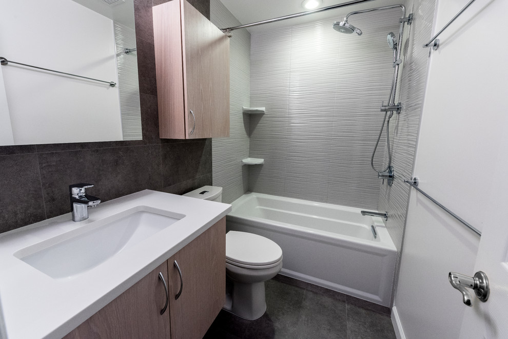 Inspiration för små moderna badrum med dusch, med släta luckor, bruna skåp, ett hörnbadkar, en dusch/badkar-kombination, en toalettstol med hel cisternkåpa, glasskiva, grå väggar, skiffergolv, ett undermonterad handfat, bänkskiva i täljsten, grått golv och dusch med duschdraperi