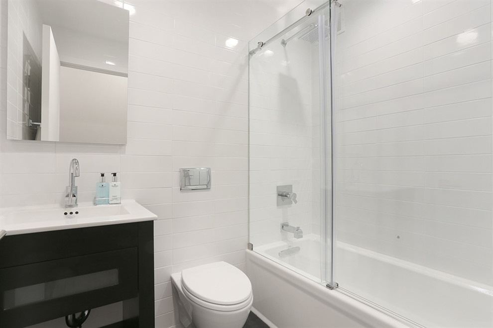 Idéer för ett mellanstort modernt en-suite badrum, med ett badkar i en alkov, en dusch/badkar-kombination, en vägghängd toalettstol, vit kakel, keramikplattor, vita väggar, ett integrerad handfat, svarta skåp, marmorbänkskiva, svart golv, dusch med skjutdörr och klinkergolv i porslin