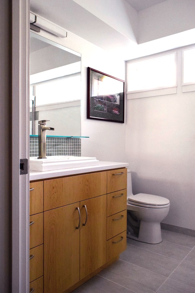Esempio di una piccola stanza da bagno moderna con ante lisce, ante in legno scuro, piastrelle verdi, piastrelle di vetro, pareti bianche, lavabo da incasso e top in superficie solida