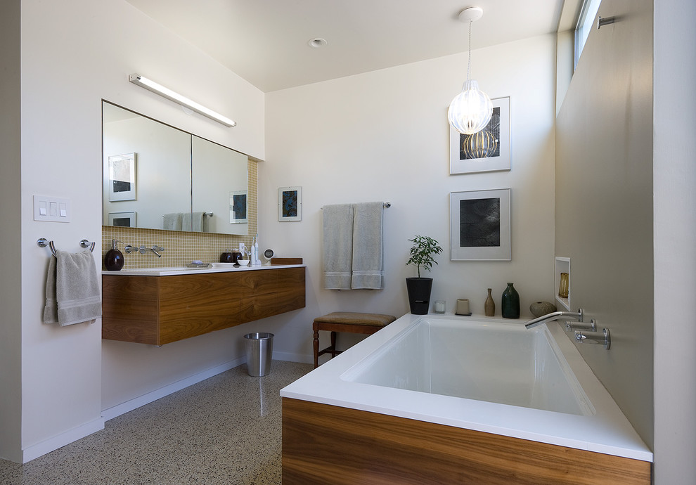 Свежая идея для дизайна: ванная комната среднего размера в стиле модернизм с врезной раковиной, плоскими фасадами, темными деревянными фасадами, полновстраиваемой ванной, белыми стенами и полом из терраццо - отличное фото интерьера