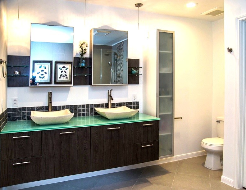 Immagine di una stanza da bagno moderna di medie dimensioni con lavabo a bacinella, ante lisce, ante in legno bruno, top in vetro e doccia a filo pavimento
