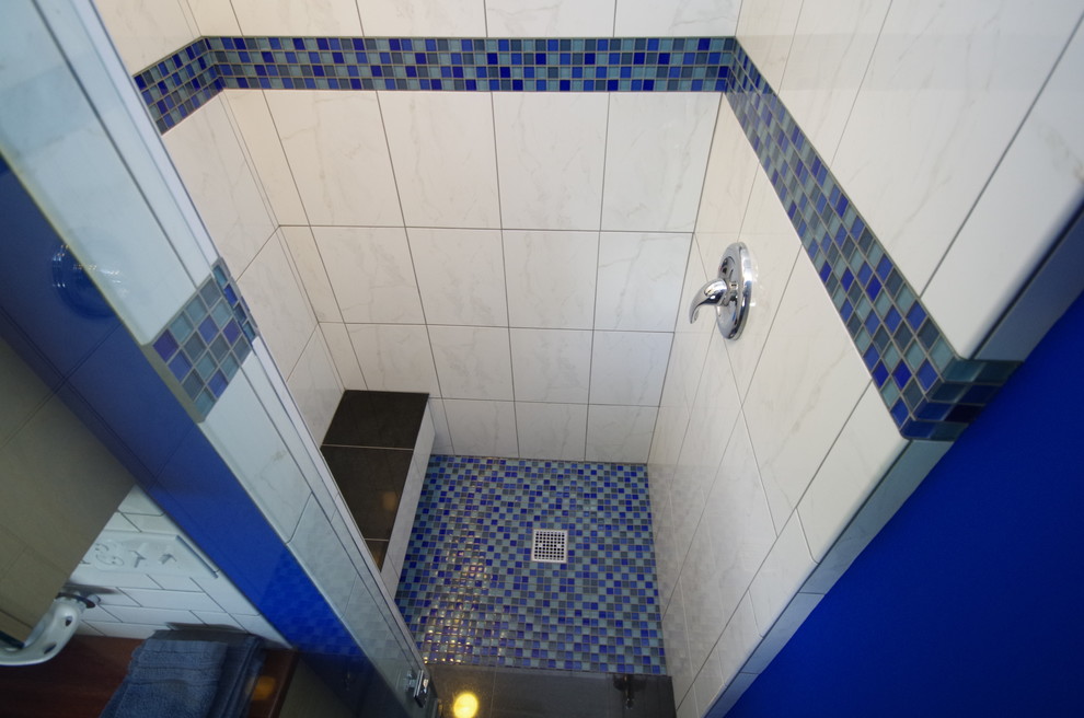 Cette image montre une salle de bain minimaliste avec WC séparés, un carrelage blanc, un carrelage métro, un mur bleu, une vasque et un plan de toilette en bois.
