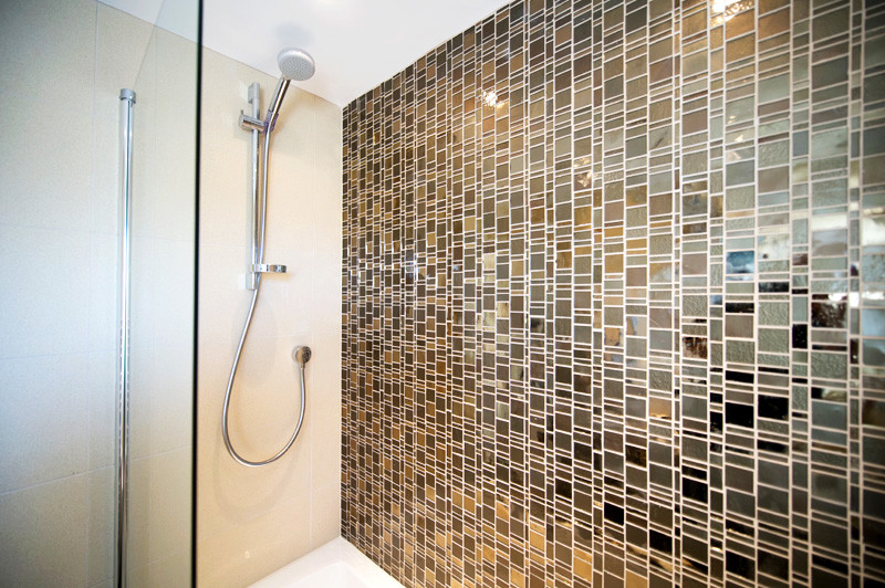 Diseño de cuarto de baño principal moderno grande con ducha a ras de suelo, baldosas y/o azulejos marrones, baldosas y/o azulejos de vidrio y paredes marrones