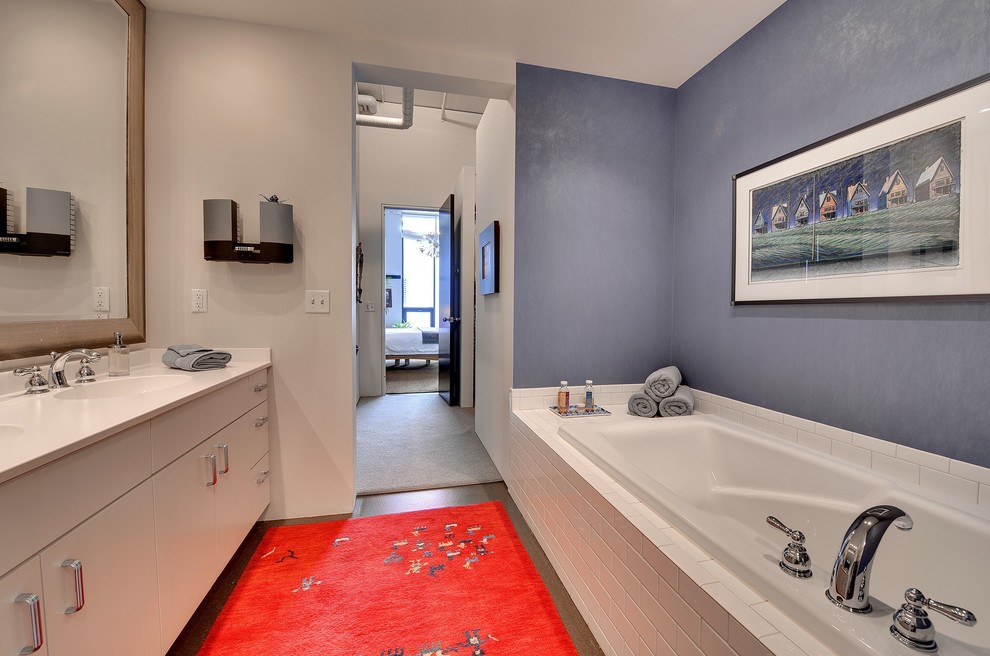Imagen de cuarto de baño minimalista con armarios con paneles lisos, puertas de armario blancas, bañera empotrada, baldosas y/o azulejos blancos y baldosas y/o azulejos de cemento