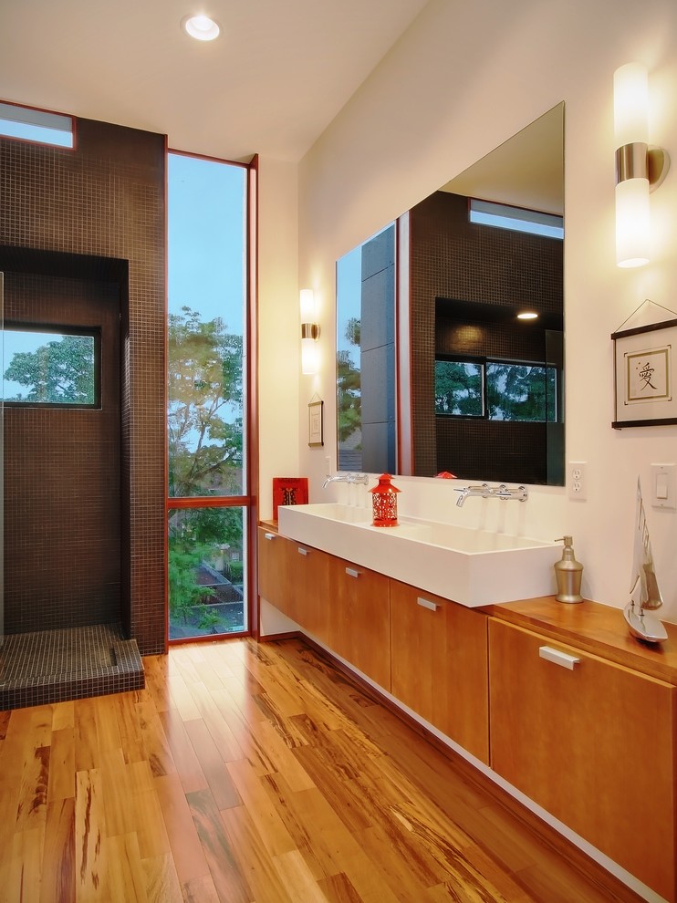 Modelo de cuarto de baño minimalista con lavabo sobreencimera, armarios con paneles lisos, puertas de armario de madera oscura, ducha abierta, baldosas y/o azulejos marrones, baldosas y/o azulejos en mosaico, ducha abierta y ventanas