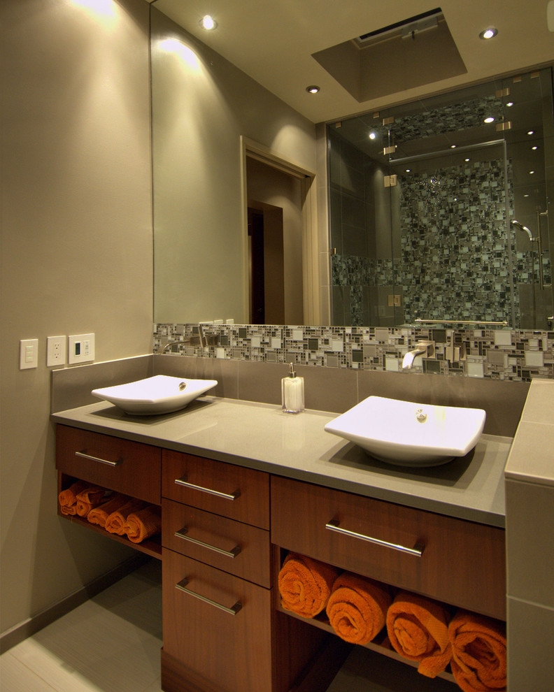 Immagine di una stanza da bagno minimalista con piastrelle a mosaico e lavabo a bacinella