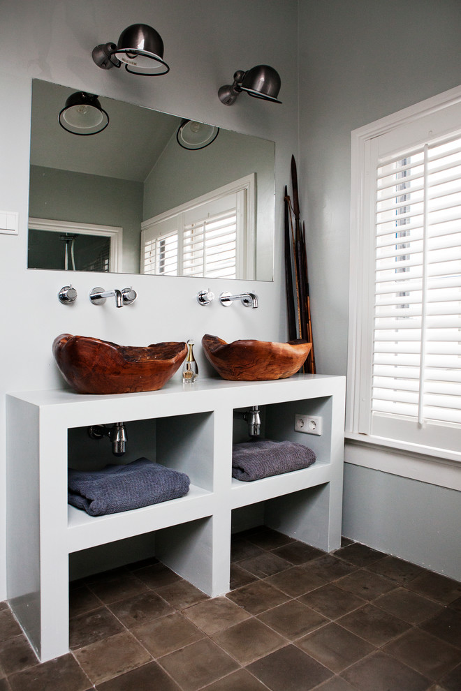Foto de cuarto de baño actual con baldosas y/o azulejos marrones, paredes grises, lavabo sobreencimera y armarios abiertos
