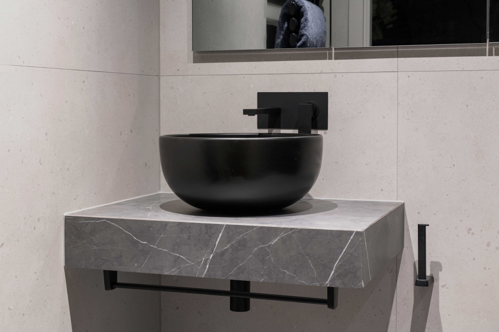 Inspiration for a medium sized contemporary shower room bathroom in London with glass-front cabinets, grey cabinets, a walk-in shower, a wall mounted toilet, grey tiles, ceramic tiles, beige walls, ceramic flooring, a vessel sink, tiled worktops, grey floors, a hinged door and grey worktops.
