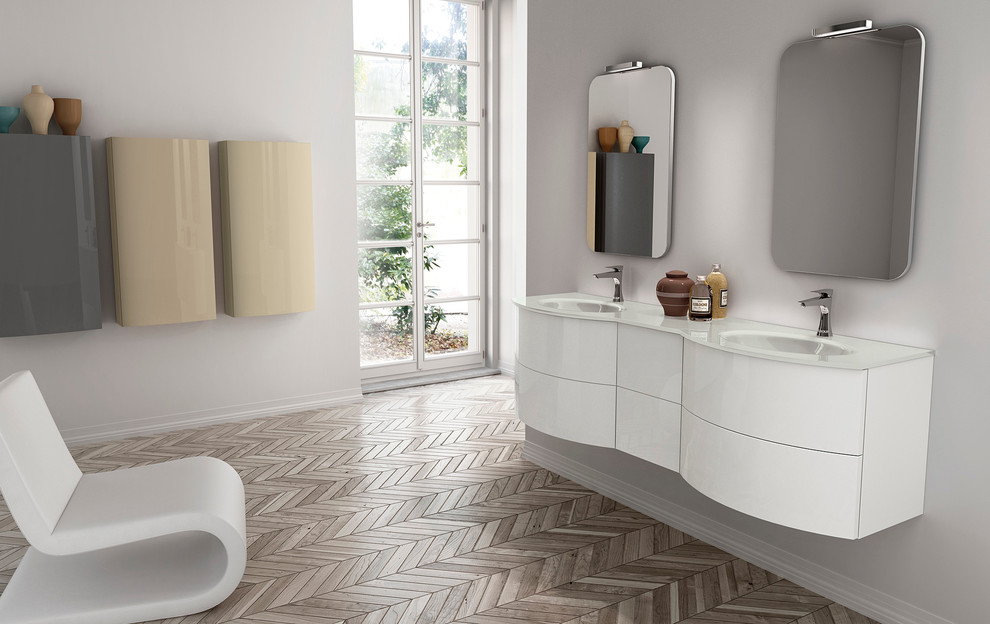 Bathroom - small modern 3/4 gray tile and ceramic tile medium tone wood floor bathroom idea in San Diego with an integrated sink, flat-panel cabinets, white cabinets, glass countertops, a one-piece toilet and gray walls