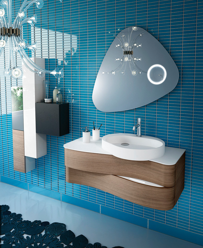 Cette photo montre une petite salle d'eau moderne en bois clair avec un lavabo intégré, un placard en trompe-l'oeil, un carrelage bleu, des carreaux de céramique, un mur bleu, un sol en carrelage de céramique, une baignoire indépendante, une douche d'angle et WC séparés.