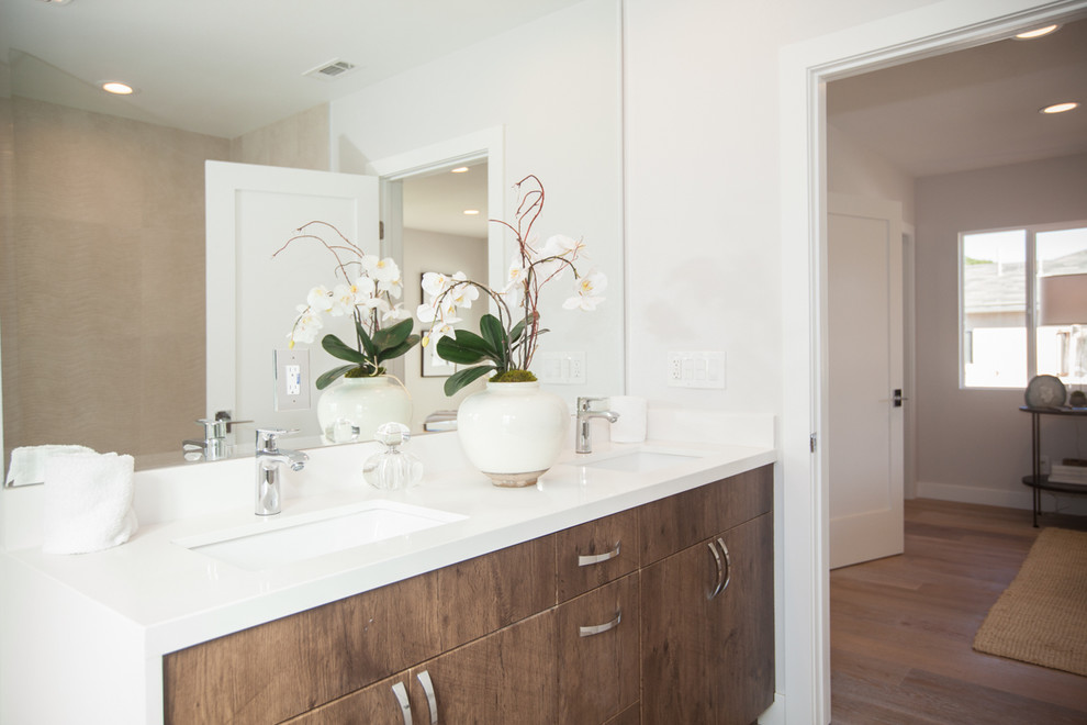 Medium sized modern bathroom in Los Angeles with a submerged sink, flat-panel cabinets, medium wood cabinets, engineered stone worktops, white walls, a shower/bath combination, a one-piece toilet, brown tiles, ceramic tiles and medium hardwood flooring.