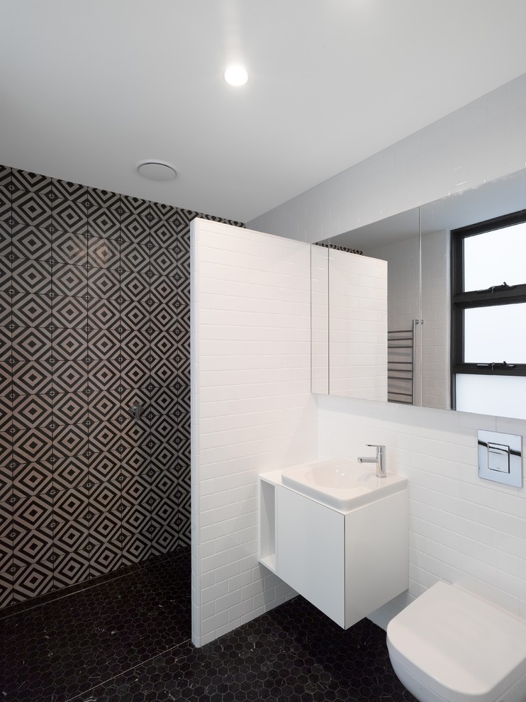 Inspiration för ett litet funkis badrum, med släta luckor, vita skåp, en öppen dusch, en vägghängd toalettstol, vit kakel, tunnelbanekakel, vita väggar, klinkergolv i keramik, ett avlångt handfat och laminatbänkskiva