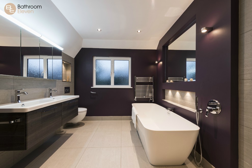 Идея дизайна: ванная комната в современном стиле с коричневыми фасадами, отдельно стоящей ванной, угловым душем, инсталляцией, керамической плиткой, фиолетовыми стенами, полом из керамической плитки, подвесной раковиной и столешницей из искусственного камня
