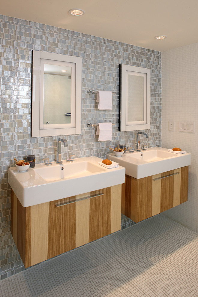 Foto di una stanza da bagno padronale minimalista di medie dimensioni con lavabo integrato, ante lisce, ante in legno scuro, piastrelle grigie, piastrelle di vetro, pareti grigie e pavimento con piastrelle a mosaico