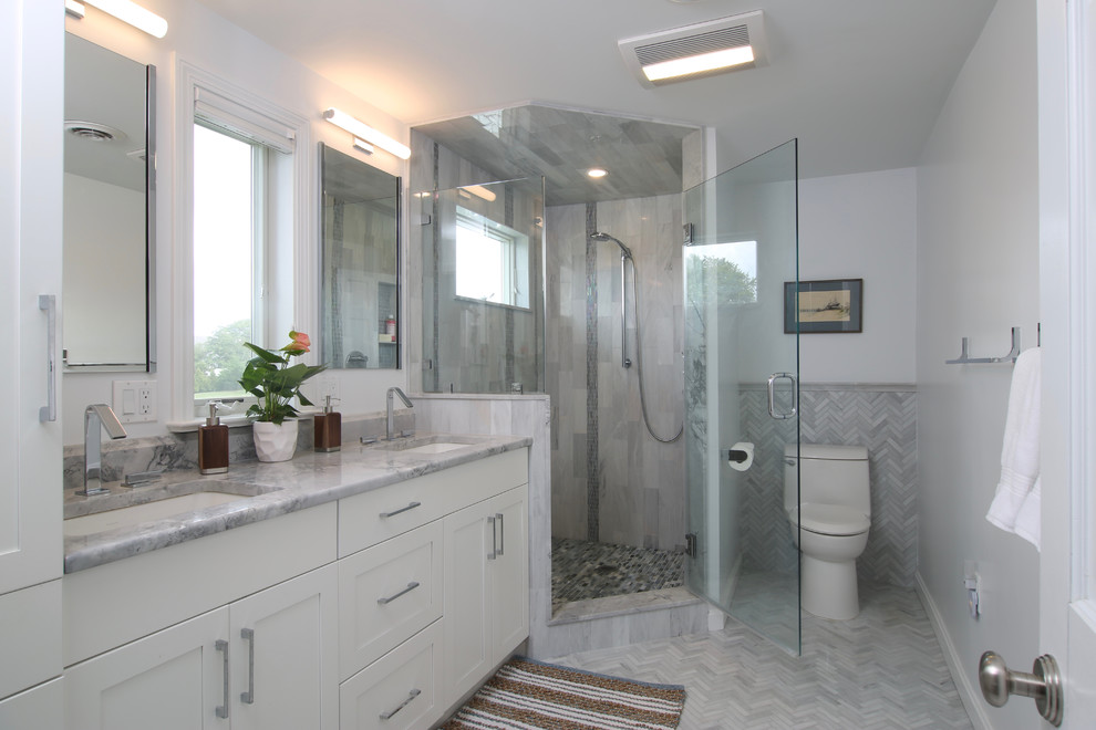 Idéer för att renovera ett mellanstort funkis en-suite badrum, med släta luckor, vita skåp, en hörndusch, en toalettstol med hel cisternkåpa, grå kakel, keramikplattor, vita väggar, klinkergolv i keramik, ett integrerad handfat och granitbänkskiva