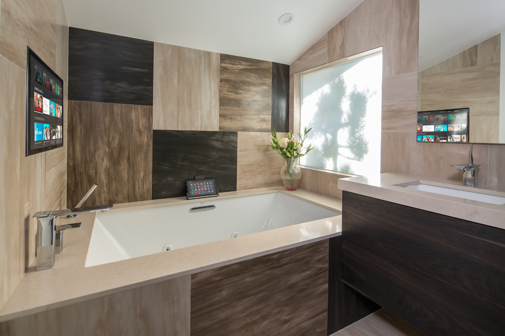 Стильный дизайн: ванная комната в современном стиле с врезной раковиной, плоскими фасадами, темными деревянными фасадами, полновстраиваемой ванной и коричневой плиткой - последний тренд