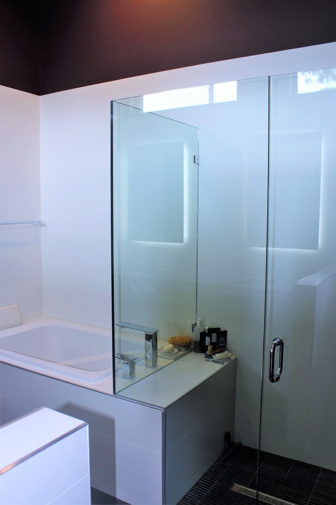 Mid-sized minimalist master white tile and stone slab bathroom photo in Miami with white walls and a hinged shower door